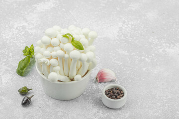 Fresh assorted shimeji mushrooms with olive oil, basil, garlic, salt, pepper on rustic background