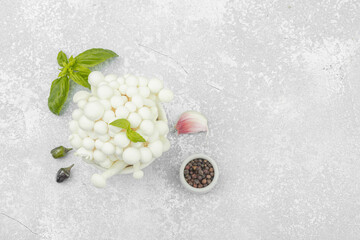 Fresh assorted shimeji mushrooms with olive oil, basil, garlic, salt, pepper on rustic background