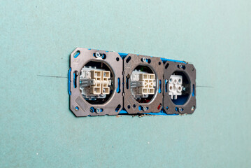 Three electrical outlets, a switch, a rosette, a fan, interior renovation of a residential building installed in a plasterboard wall. Telsiai,Lithuania. 08-26-2025.