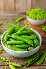 Fresh green pea pods with green peas on a wooden background. Sweet green peas. Green pea beans vegetables. Vegan. healthy vegetable. Copy space