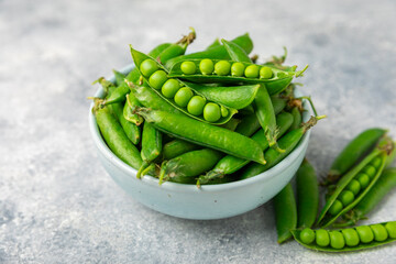 Fresh green pea pods with green peas on a wooden background. Sweet green peas. Green pea beans vegetables. Vegan. healthy vegetable. Copy space