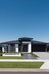Modern residential architecture shines under a clear blue sky, showcasing sleek design and lush landscaping in a tranquil neighborhood setting