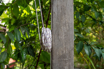 a rope tied with stitches to a 'frog' attached to a pole