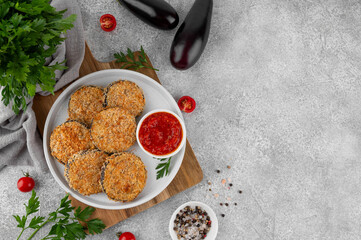 Baked garlic crispy eggplant with tomato sauce on a plate. Vegetarian food. Selective focus, top view.