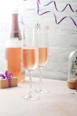 Two glasses and a bottle with pink champagne, New Year eve
