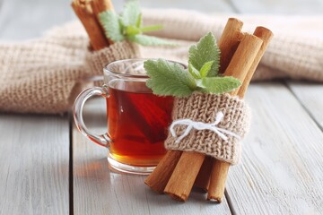Warm apple cider with cinnamon sticks and mint on rustic wood, cozy autumn still life, soft focus, muted color palette, comforting, hygge vibes