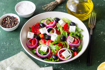 Greek salad with feta cheese, tomatoes, onion, cucumbers, peppers and olives. Healthy eating. Vegetarian food.