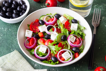 Greek salad with feta cheese, tomatoes, onion, cucumbers, peppers and olives. Healthy eating. Vegetarian food.