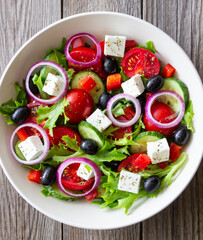 Greek salad with feta cheese, tomatoes, onion, cucumbers, peppers and olives. Healthy eating. Vegetarian food.