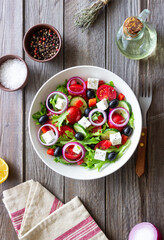 Greek salad with feta cheese, tomatoes, onion, cucumbers, peppers and olives. Healthy eating. Vegetarian food.