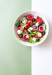 Greek salad with feta cheese, tomatoes, onion, cucumbers, peppers and olives. Healthy eating. Vegetarian food.