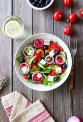 Greek salad with feta cheese, tomatoes, onion, cucumbers, peppers and olives. Healthy eating. Vegetarian food.