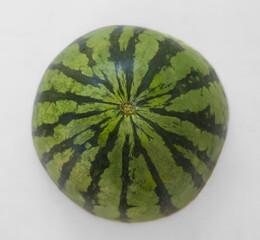 Green lined peel texture , one 1 half striped watermelon isolated on white background with copy space for text or images. Side view. Close-up shot.