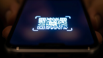 Scanning QR code with smartphone for payment processing, mobile scanning QR code is the modern solution. Mobile payment using QR code is a popular method for cashless transactions.