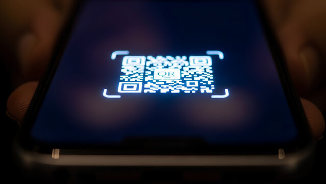 Scanning QR code with smartphone for payment processing, mobile scanning QR code is the modern solution. Mobile payment using QR code is a popular method for cashless transactions.