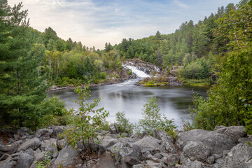 Stunning view of Onaping Falls surrounded by lush forests in Ontario, capturing the serene beauty and tranquility of Northern Canadian wilderness.