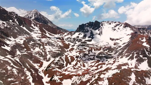 Mt Mount Lindsey Blanca Peak Sangre De Cristo Range aerial drone Colorado spring summer snow fields melting morning blue sky clouds high Rocky Mountains summit Fort Garland backwards motion