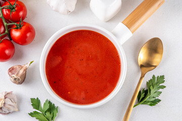 Tasty tomato cream soup. Delicious hot fall season gazpacho creamy pureed soup with garlic and aromatic herbs. Autumn and winter comfort food, tasty vegan vegetable recipe