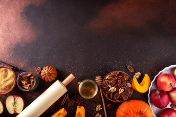 Fall baking, cooking seasonal dessert background with various ingredients - honey, pumpkin squash, brown sugar, cinnamon, spices, red apples, walnuts, pecans. Autumn, thanksgiving bakery background