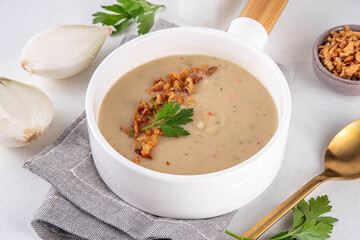 Cream of onion soup puree. White onion cream soup with crunchy caramelized fried onion topping. Autumn and winter comfort food, tasty vegan vegetable recipe