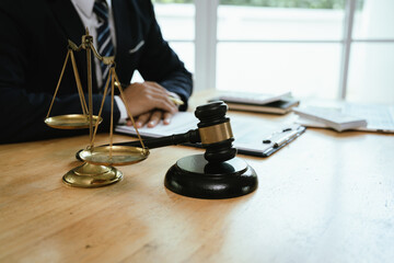 A professional male lawyer sits at a desk with documents and gavel, symbolizing law, judgement, authority, justice, and legal expertise.