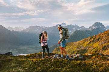 Obraz premium Friends couple hiking in Norway man and woman travel outdoor active vacations healthy lifestyle romantic tour, family mountaineering in Lofoten islands adventure trip boyfriend and girlfriend tourists