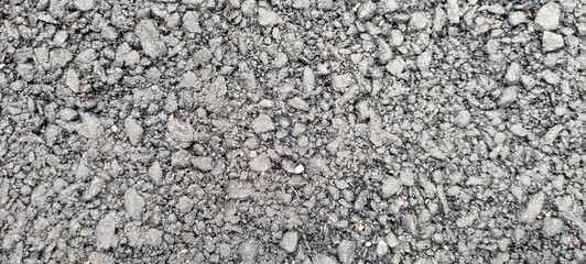 Close-up of a surface covered in small, gray, angular rocks or gravel, creating a textured and detailed background.