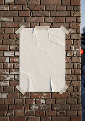 Blank Crumpled Poster on Weathered Brick Wall Secured with Tape Urban Texture.