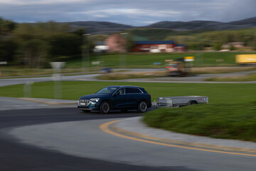 Car with trailer at full speed with the background blurred by the motion.