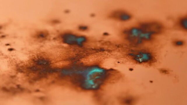 A time-lapse of rust and patina forming over a sheet of copper, showing shades of brown and vibrant verdigris