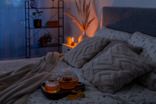 cup of tea on cozy bed with autumn decorations