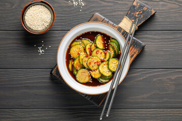 Korean trendy cucumber spiced salad in a bowl on the table. Top view