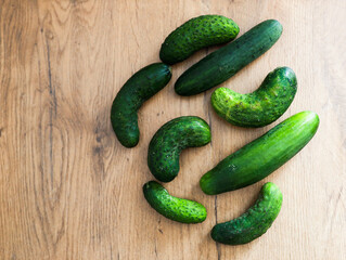 Fresh Cucumbers Arranged on a Wooden Surface in Various Shapes