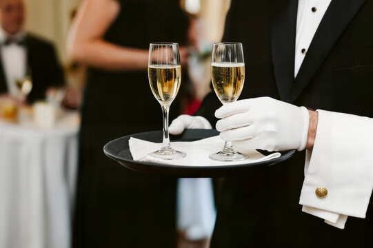 waiter in uniform concept champagne glasses on a tray camarero con uniforme con copas de champ&aacute;n en una bandeja serveur en uniforme concept coupes de champagne sur un plateau garson