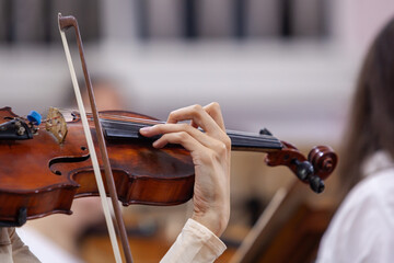  Hand of a girl playing the violin in an orchestra