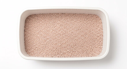 Clean white litter box filled with fresh absorbent granular sand for cats. Top view of a pet toilet for domestic feline hygiene, isolated on a white background