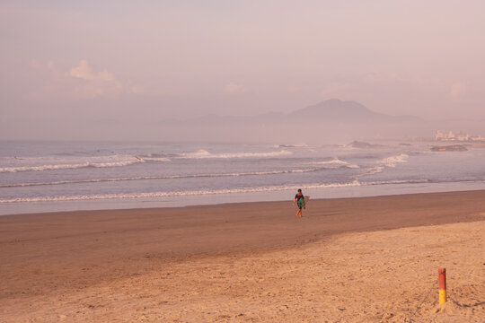 Surfist walking on the beach