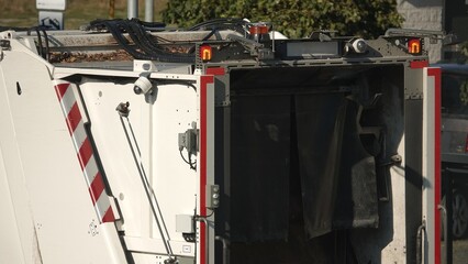 Śmieciarka pod altaną śmietnikową odbierająca śmieci © tomo81