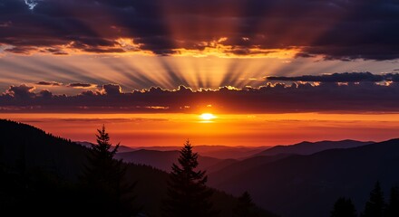 Closeup of a Beautiful Sunset over Mountains with Glowing Rays Piercing Dramatic Clouds and Fiery Color Palette"