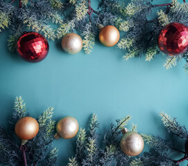 green background with gold and red Christmas balls and pine branch and space for text