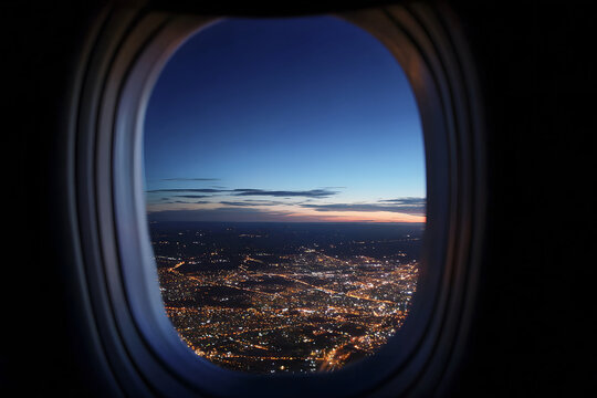 Aerial view through airplane window at night during the golden hour