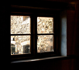 Fototapeta premium A window with a view of a stone wall.