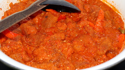 Spicy Indonesian cowhide crackers cooked in red chili sauce, traditional Asian street food cuisine
