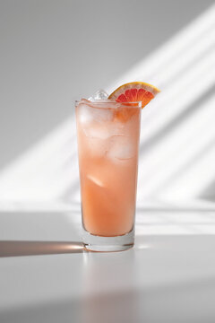 Refreshing cocktail served in tall glass with ice and citrus garnish on a sunny day
