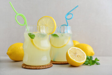 Two glasses of homemade lemonade with drinking straws