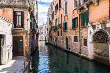Venetian Canal: A tranquil waterway winds through aged buildings, reflecting the sky in Venice's iconic setting.