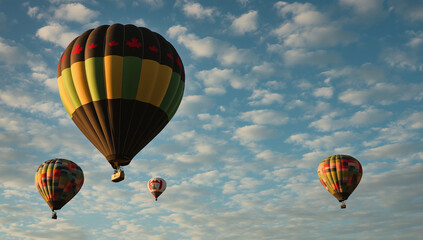 Several hot air balloons float in a blue sky with scattered clouds.