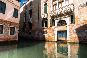 Venetian buildings cast reflections on the water, capturing the timeless allure of its historic architecture and tranquil canals.