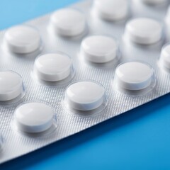 Close-up of blister pack with white pills on a blue background, pharmaceutical