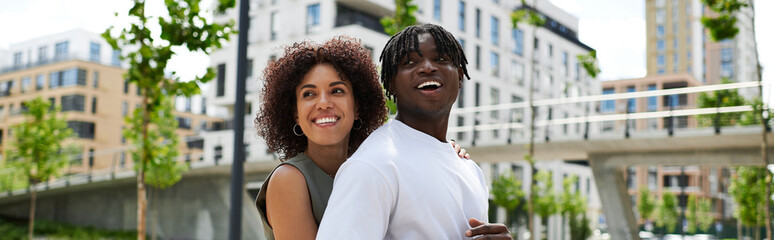 Joyful summer date of a fashionable young couple enjoying urban life together